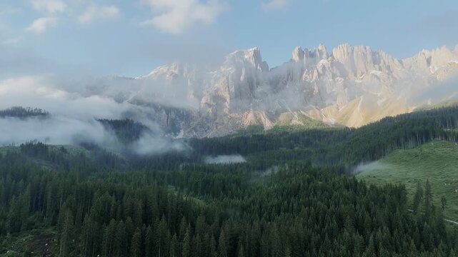 Paysage cin&eacute;matographique par drone du Lac de Carezza avec reflet des montagnes et brume matinale, Alpes Italienne