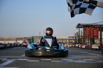 A go-kart racer prepares to hit the track as sunset casts a warm glow.