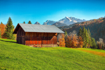 Fabulous view of alpine meadow with wooden huts  near Wagenbruchsee (Geroldsee) lake