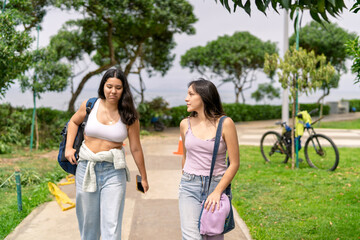 Naklejka premium Young women friends walking relaxing by the sea park