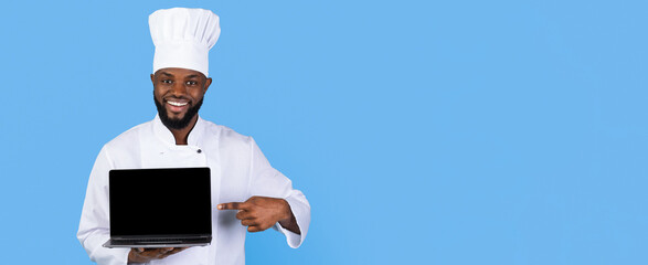 A professional chef wearing a white uniform and hat stands against a bright blue background. He smiles and gestures to a laptop, suggesting digital cooking resources or technology in the kitchen.