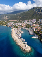 Obraz premium Aerial view of Kaş, with its colorful houses, a small harbor, turquoise waters, and surrounding rocky hills in Antalya, Turkey.