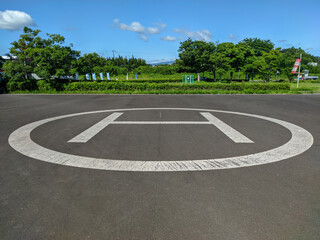アスファルトの路面のヘリコプター着陸用のヘリポートのサイン