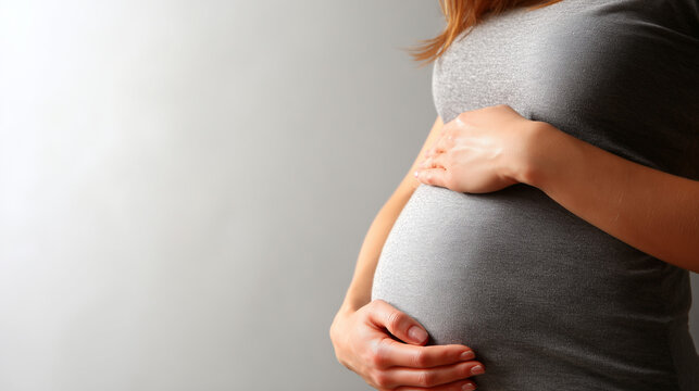 Pregnant Woman Holding Baby Bump In Gray Maternity Shirt For Expecting Mother - Powered by Adobe