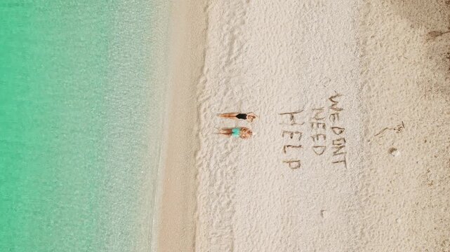 Sunny Cephalonia shore with two people lying on pebbles beside bright turquoise sea water