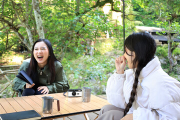 Two Asian Young Woman Sitting in front of Camping Glamping Tent