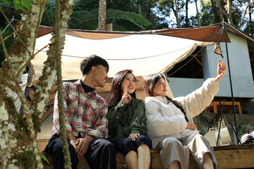 Asian Young People Taking Group Selfie Photo in front of Camping Tent