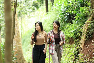 Two Young Asian Female Hikers Enjoying an Outdoor Adventure in Nature.