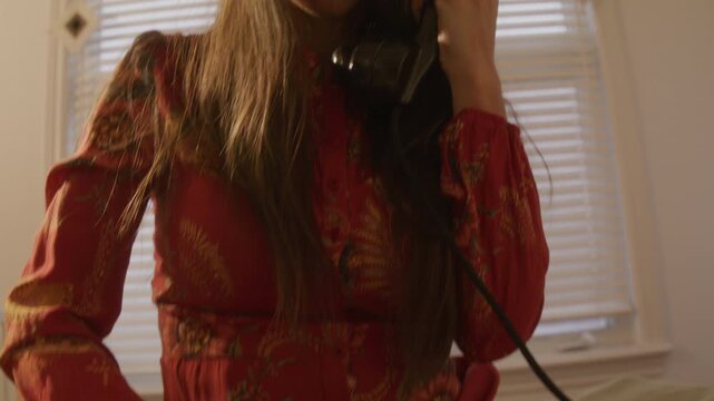 Retro dreamcore woman sits on bed and dials on old rotarty phone - move from hands to face