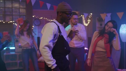 An enthusiastic male dancer showcases bold moves in lively nightclub environment filled with friends and music