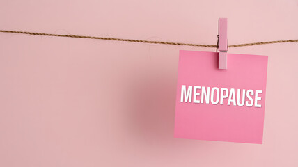 Menopause Awareness Concept on a Pink Sticky Note Hanging from a Twine String
