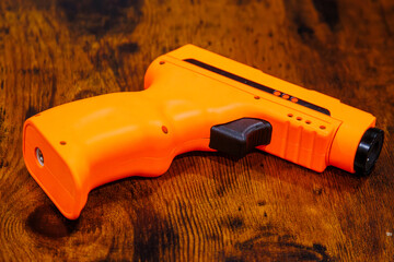 An orange butane torch on a wooden surface