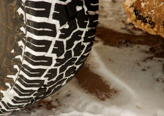 A tire with snow in the treads during winter