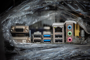 desktop PC motherboard rear I-O panel showing VGA and DVI video outputs, multiple USB ports, an Ethernet RJ45 socket, and color-coded audio jacks used to connect peripherals on a computer back panel.