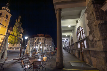 View of the empty cafe terraces and colonnades of the Ljubljana Central Market at night, designed by architect Joze Plecnik in the 19th century, in slovenia.