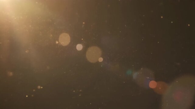 Aerial view of glowing lights in a dark environment with lens flares and bokeh effects