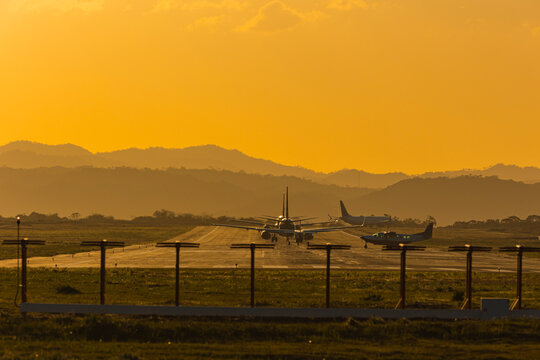 Silhouette of small aircraft taxiing on the airport runway at sunset in Liberia Costa Rica
