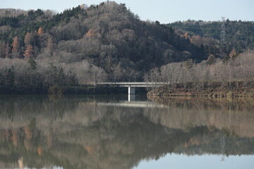 紅葉時期が過ぎ去り色あせてしまった、11月中旬のダム湖畔