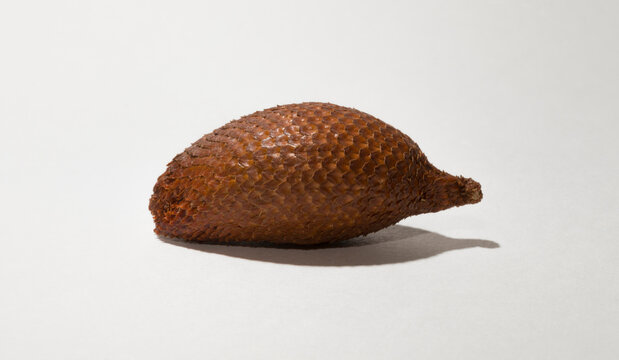 Salak (Salacca zalacca) is a species of palm tree (family Arecaceae), snake fruit or snakeskin fruit due. One fruit on a white background.