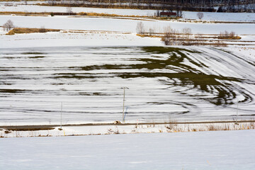 雪が溶け始めた早春の畑
