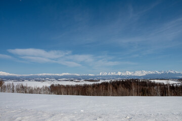 冬の青空と雪原と山並み　十勝岳連峰
