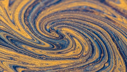 Abstract swirling gold and blue liquid texture with metallic glitter, macro fluid art background