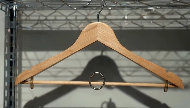 Clean 4K retail close up of empty wooden clothing hangers hanging neatly on metal rack symbolizing shopping fashion retail discounts minimal store 