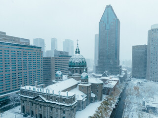 Snowy aerial view of Montreal downtown with Mary Queen of the World Cathedral during snowfall and...