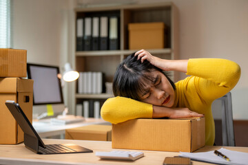 Stressed asian woman running sme feeling tired from online selling at home office