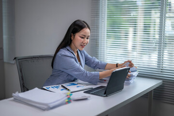 Asian businesswoman working with documents and digital tablet in office