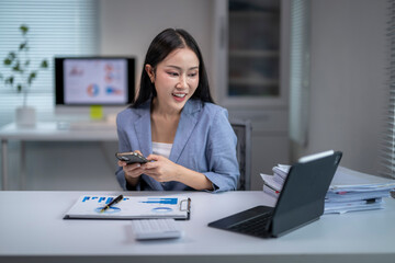 Young office worker analyzing marketing data using mobile phone and digital tablet
