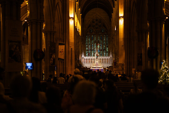 Cathedral worshipers, stained glass, Christmas service, solemn