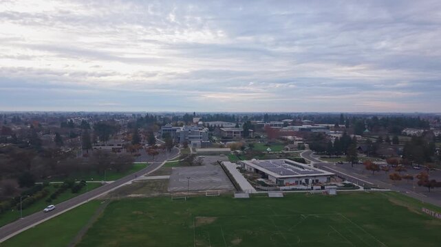 A panning view reveals CSU Stanislaus at dusk on a cloudy day, highlighting geometry and landscaped grounds of the campus.