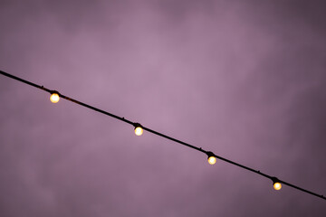 Warm string lights glow against twilight sky