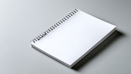 A blank spiral-bound notebook rests on a plain gray surface