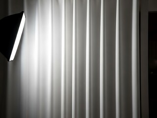 Studio lighting illuminating flowing white fabric backdrop in monochrome