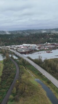 Overcast Aerial Perspective of a Major Bridge, Railway, and Industrial Riverfront in British Columbia, Canada