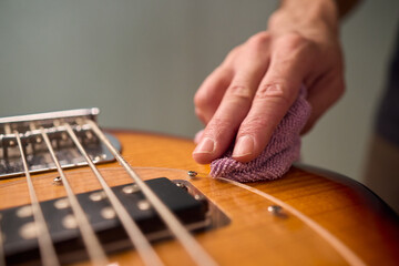 Closeup of guitar care and preparation process with studio lighting, Careful guitar body polishing...