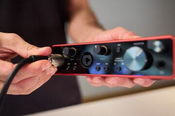 Preparation scene of connecting instrument cable to audio interface for recording, Detailed view of...