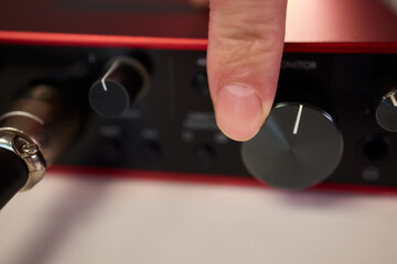 Adjusting audio controls, Precise handling of control knobs on audio equipment during setup, Fingers align control dials on audio interface for optimal sound calibration © Евгений Вершинин