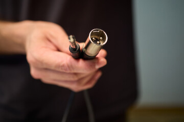 Setting up audio connection professionally, Attaching sound cable to subwoofer in studio, Closeup of hands securing audio cable into subwoofer in recording studio setting © Евгений Вершинин