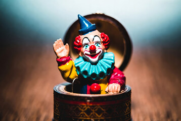The box suddenly opens and a clown figure suddenly jumps out of it, frightening everyone around.