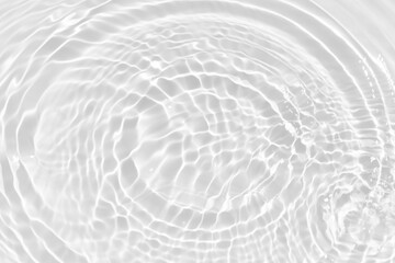 White water with ripples on the surface. Defocus blurred transparent white colored clear calm water surface texture with splashes and bubbles. Water waves with shining pattern texture background.