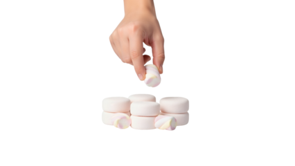 A person's hand places a pink and white marshmallow onto a small stack of similar treats against a black background