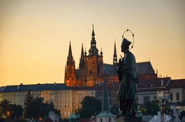 Fototapeten Prag Czech Republic, Prague September 6, 2025, the statue of John of Nepomuk on the Charles Bridge in Prague, with the castle on the Hradčany in the background and the setting sun  © Pawel Filusz