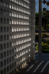 interplay of light and shadow creates captivating pattern on textured wall, enhancing architectural beauty of space