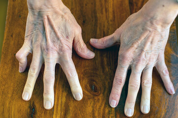 old woman's hands on a wooden table