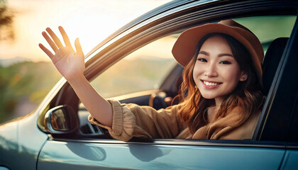 若い女性が車の窓から手を出して振っている。夕日をバックしてしている。笑顔がかわいい。