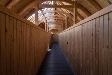 Long vaulted wooden corridor with skylights offering a natural light pathway