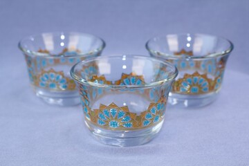 Set of three clear glass traditional Arabic coffee cups finjan with blue and gold geometric design